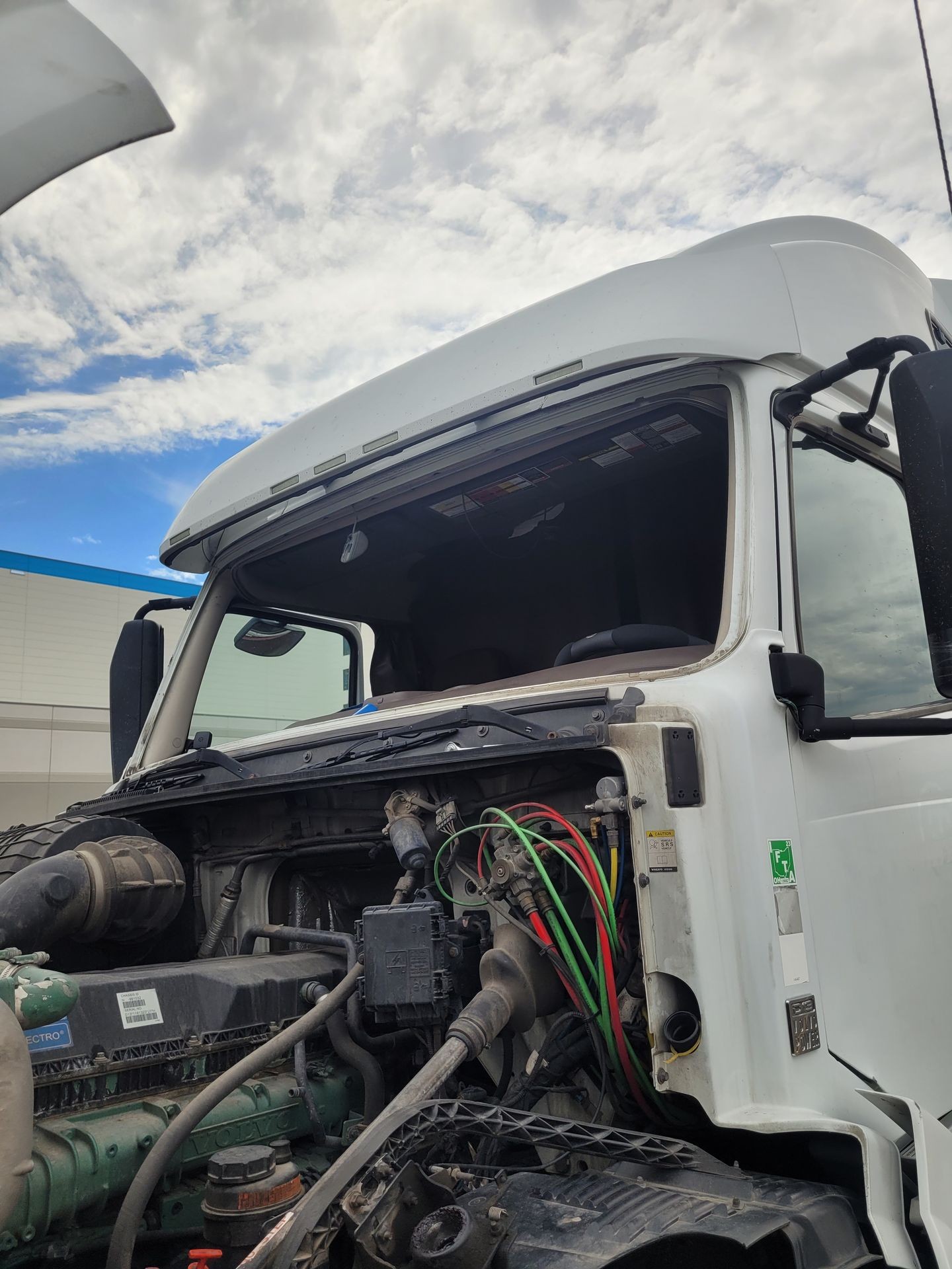 Technician performing a semi-truck windshield replacement in Modesto, California with mobile auto glass service.